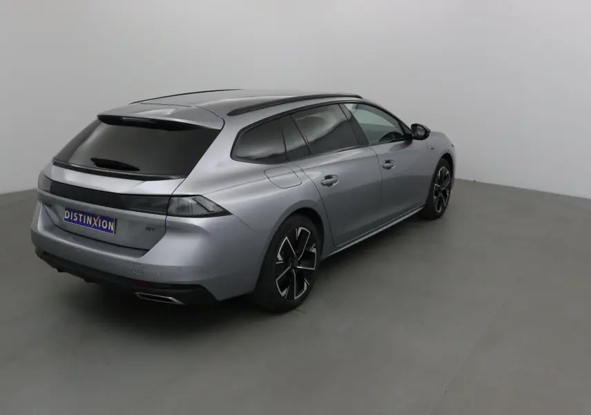 Peugeot 508 SW gris Artense vue 3/4 arrière droit, avec vitres teintées et jantes noires distinctives.