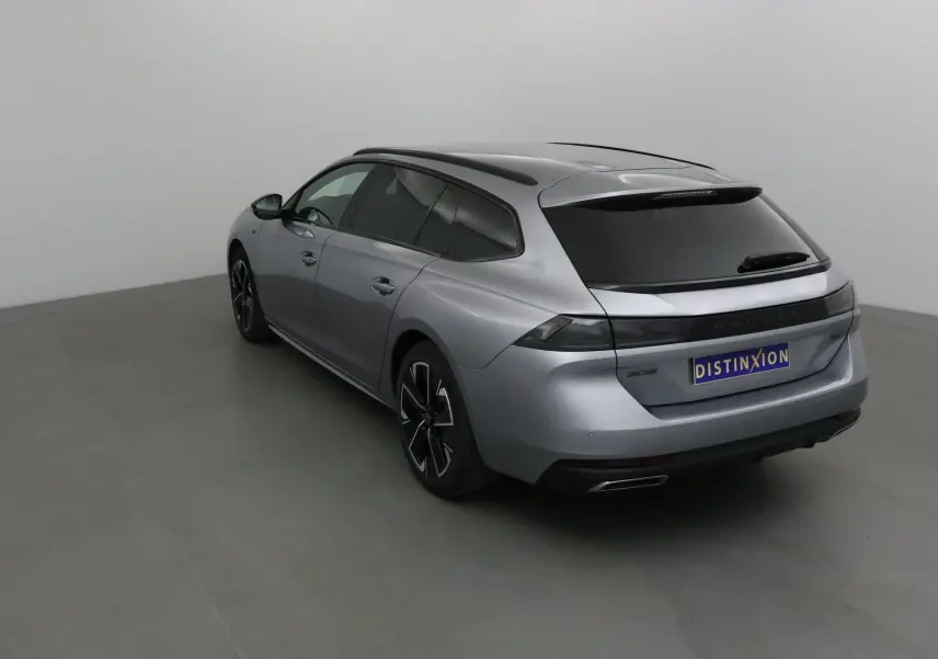 Peugeot 508 SW gris Artense vue 3/4 arrière droit, avec vitres teintées et jantes noires distinctives.