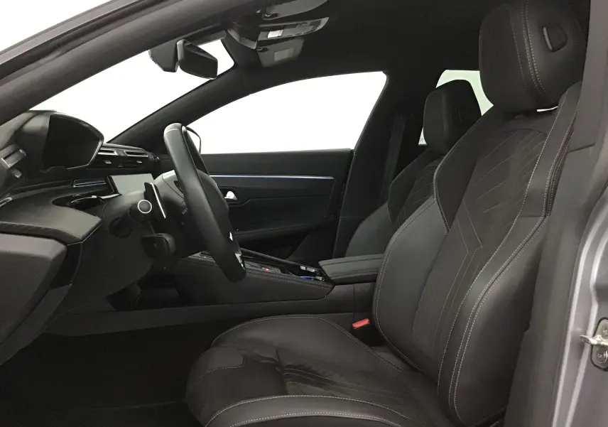 Intérieur côté conducteur de la Peugeot 508 SW 2024 gris Artense, sièges cuir et tableau de bord moderne.