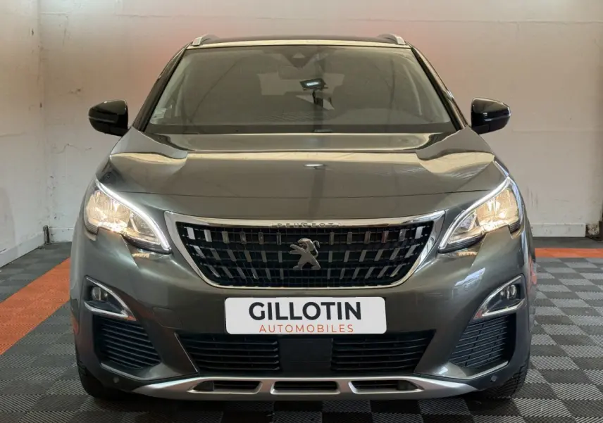 Vue frontale d'un Peugeot 3008 vert 2020 avec phares allumés et calandre noire distinctive.