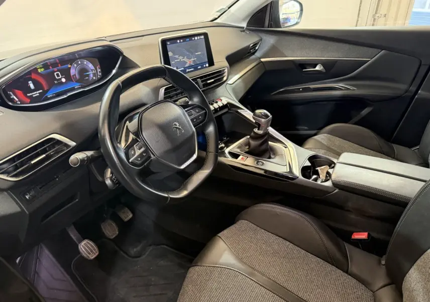 Vue intérieure côté conducteur du Peugeot 3008 vert 2020, volant cuir, écran tactile central et boîte manuelle.