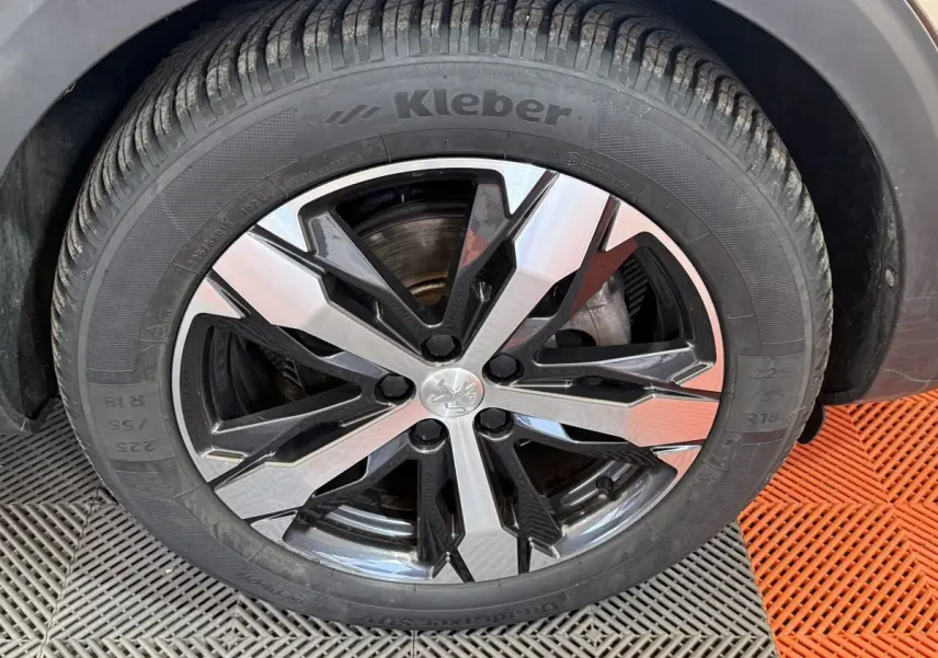 Gros plan sur la jante avant droite du Peugeot 3008 vert, avec pneu Kleber et design en alliage bicolore noir et argent.