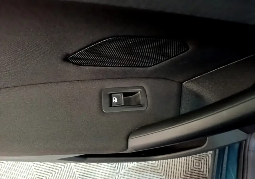 Détail de la poignée intérieure de porte arrière côté droit du Volkswagen Tiguan 1.4 eHybrid bleu.