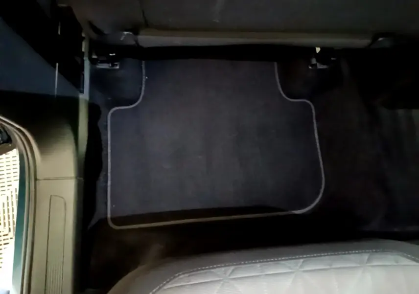 Vue intérieure du tapis de sol noir côté passager arrière du Volkswagen Tiguan hybride rechargeable bleu 2021.