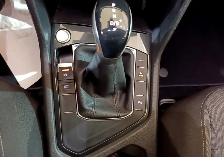 Gros plan sur la console centrale du Volkswagen Tiguan 1.4 eHybrid 2021 avec levier de vitesse automatique et boutons de contrôle.