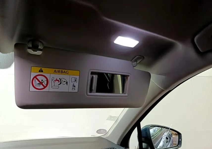 Détail du pare-soleil côté conducteur avec miroir intégré et rétroviseur extérieur bleu du Volkswagen Tiguan 1.4 eHybrid.