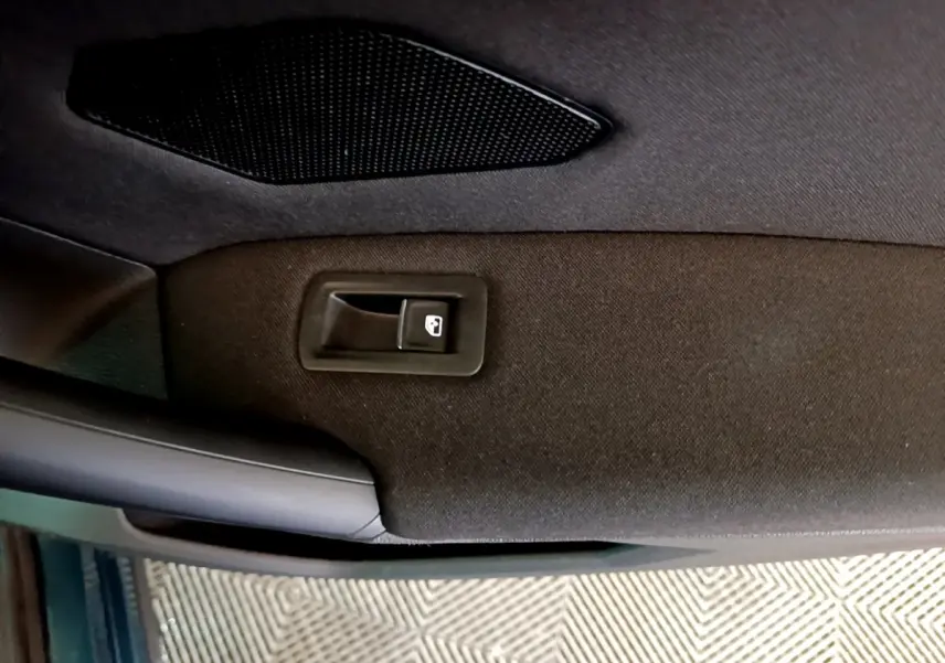 Détail de la porte intérieure côté conducteur du Volkswagen Tiguan bleu, avec bouton de verrouillage centralisé.