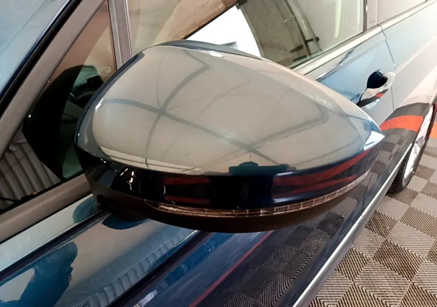 Gros plan sur le rétroviseur droit bleu du Volkswagen Tiguan 1.4 eHybrid 245 DSG6, avec clignotant intégré.