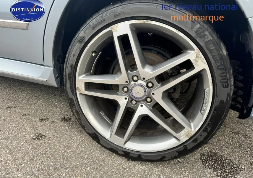 Gros plan sur la jante alu AMG argentée du côté avant droit d'une Mercedes GLK 350 4matic noire de 2014.