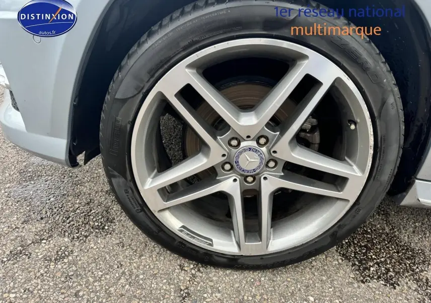 Gros plan sur la jante alu argentée et le pneu Pirelli d’un Mercedes GLK noir, côté avant droit.
