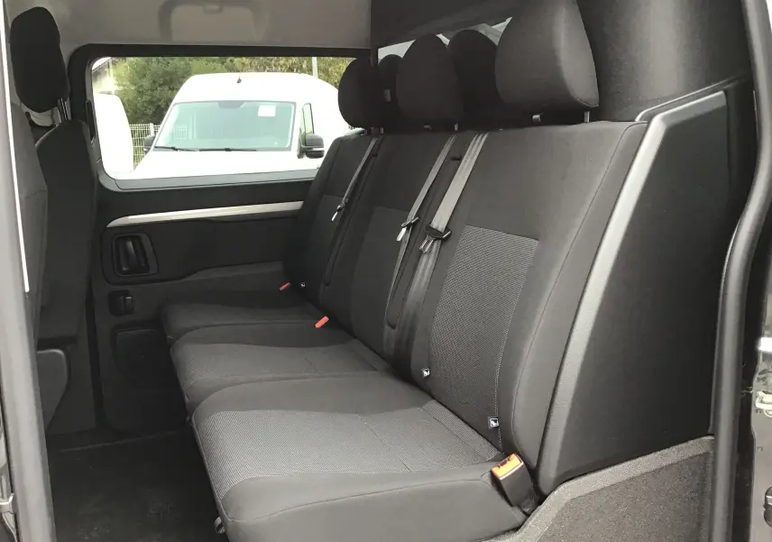 Vue intérieure côté droit des sièges arrière noirs du Peugeot Expert Cabine Approfondie gris titane, avec ceintures de sécurité visibles.