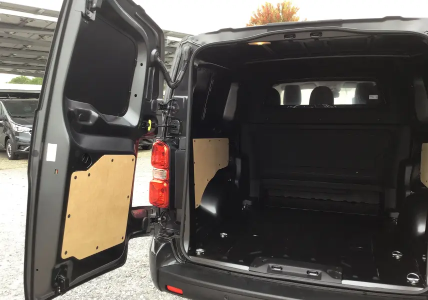 Vue arrière ouverte du Peugeot Expert Cabine Approfondie gris titane, montrant l’espace de chargement vide et les portes battantes.