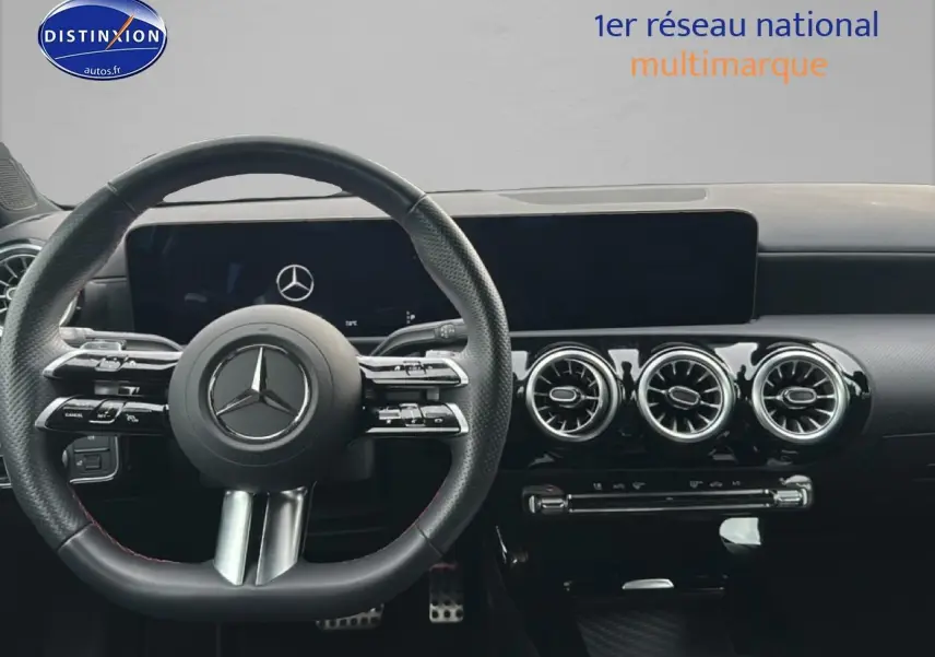 Vue intérieure centrée sur le volant cuir multifonction et la planche de bord noire du Mercedes Classe A 180 AMG Line.