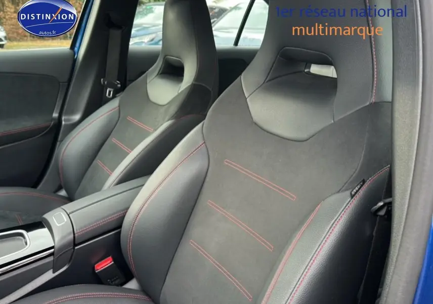 Gros plan sur les sièges avant sport noirs avec surpiqûres rouges dans une Mercedes Classe A 180 AMG Line bleu.