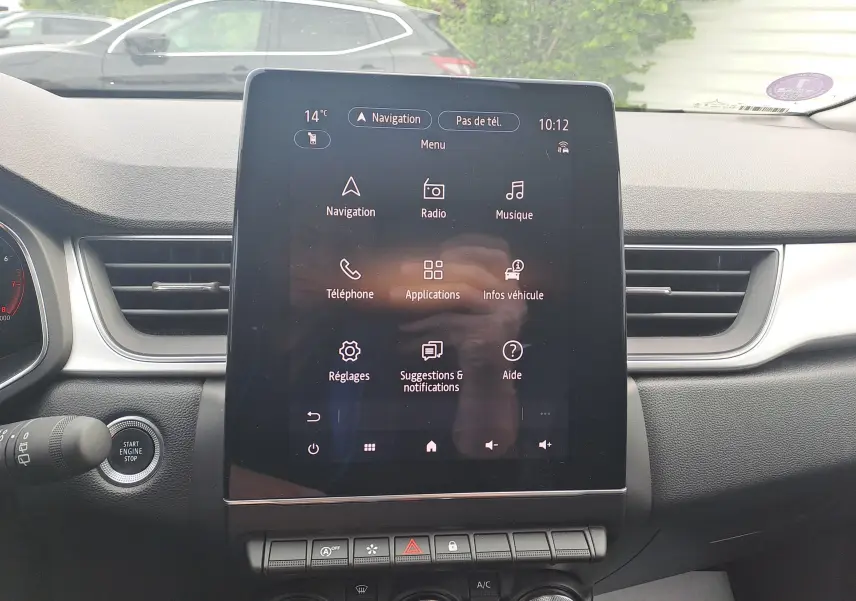 Vue intérieure centrée sur l'écran tactile du tableau de bord du Renault Captur 2022, avec commandes et aérateurs visibles.