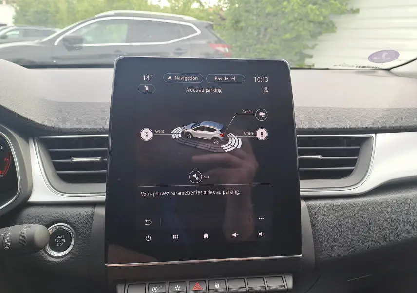 Vue intérieure du tableau de bord du Renault Captur 2022 avec écran tactile affichant l'aide au parking.