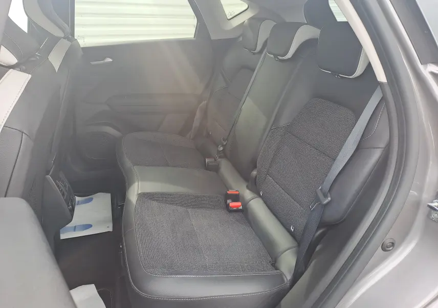 Vue intérieure côté droit des sièges arrière du Renault Captur 2022, sellerie tissu noir avec surpiqûres grises.