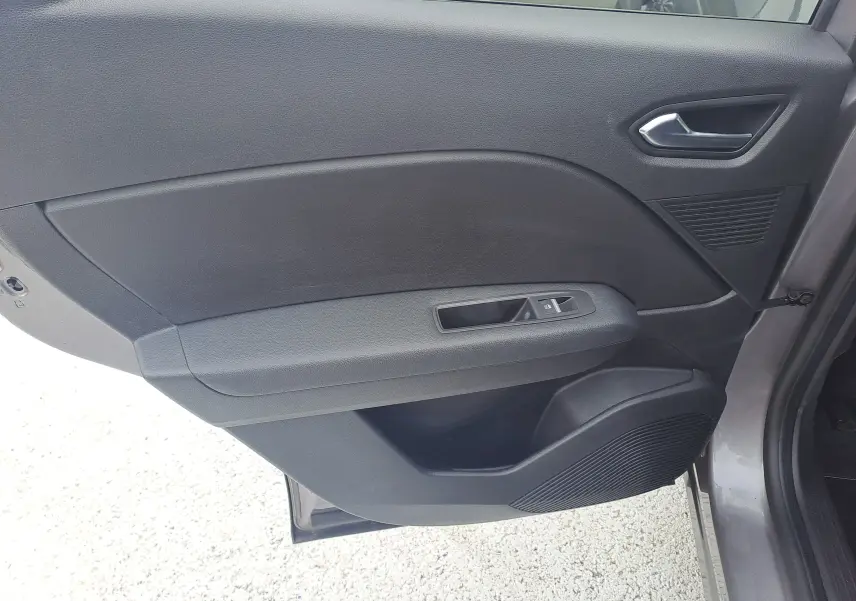 Vue intérieure de la porte arrière droite du Renault Captur gris Cassiopée avec poignée et commande de vitre noire.
