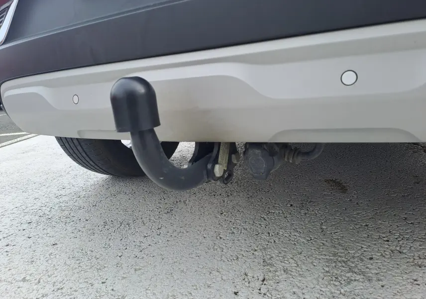 Gros plan sur l'attelage noir sous le pare-chocs arrière gris cassiopée du Renault Captur 2022.