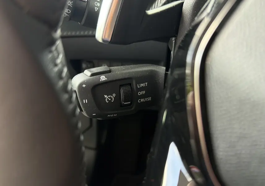 Gros plan sur la commande de régulateur de vitesse à gauche du volant du Peugeot 2008 gris Sellenium 2023.