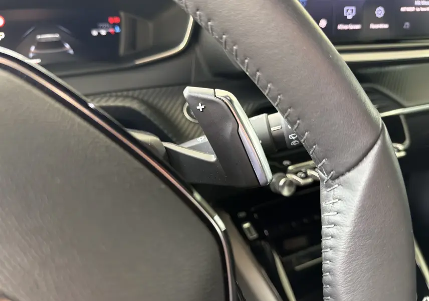 Gros plan sur la palette de passage de vitesses droite en cuir noir du volant du Peugeot 2008 gris Sellenium 2023.