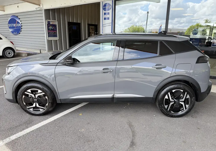 Profil côté gauche du Peugeot 2008 gris Sellenium 2023, avec jantes bi-ton et toit noir contrasté.