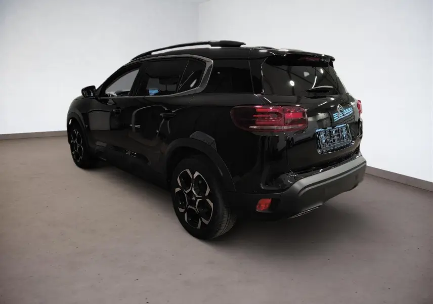 Vue 3/4 arrière droite d'un Citroën C5 Aircross noir Perla avec jantes alliage bi-ton et vitres surteintées.