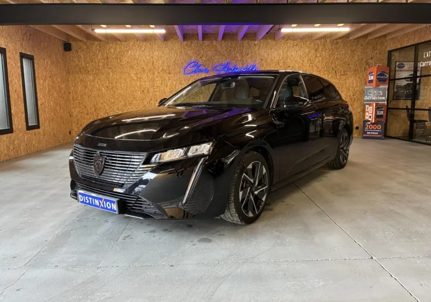 Peugeot 308 SW noire vue en 3/4 avant droit, avec calandre chromée et jantes alliage 17 pouces.