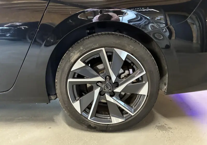 Gros plan sur la roue arrière droite d’une Peugeot 308 SW noire avec jante alliage 17'' au design géométrique.
