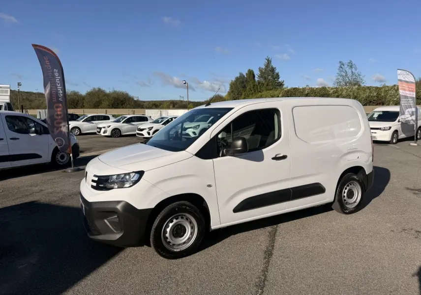 Peugeot Partner blanc en vue 3/4 avant droit, avec protections noires latérales et jantes acier simples.