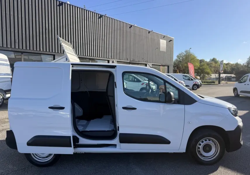 Vue latérale droite d’un Peugeot Partner blanc 2026 avec porte coulissante ouverte montrant l’espace de chargement.