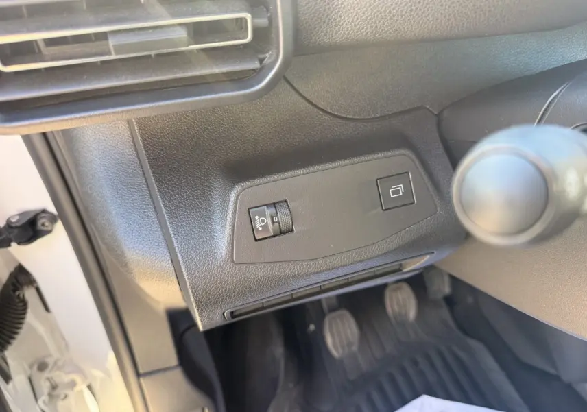 Détail intérieur côté conducteur du Peugeot Partner blanc 2026 montrant les commandes d'éclairage et la boîte manuelle.