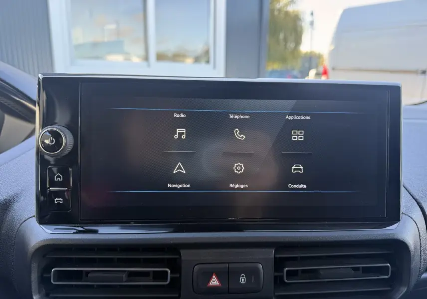 Écran tactile central du tableau de bord du Peugeot Partner 2026, affichant les options radio, téléphone et navigation.