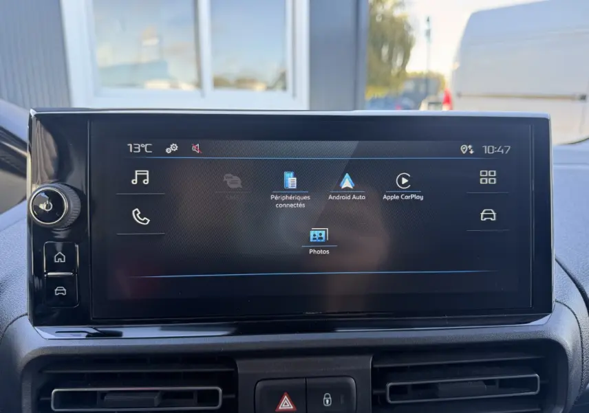 Écran tactile central du Peugeot Partner blanc, vue intérieure frontale avec commandes multimédias affichées.
