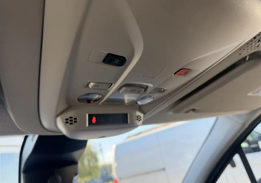 Vue intérieure du plafond avant du Peugeot Partner blanc 2026, montrant les commandes d'éclairage et l'appel d'urgence.