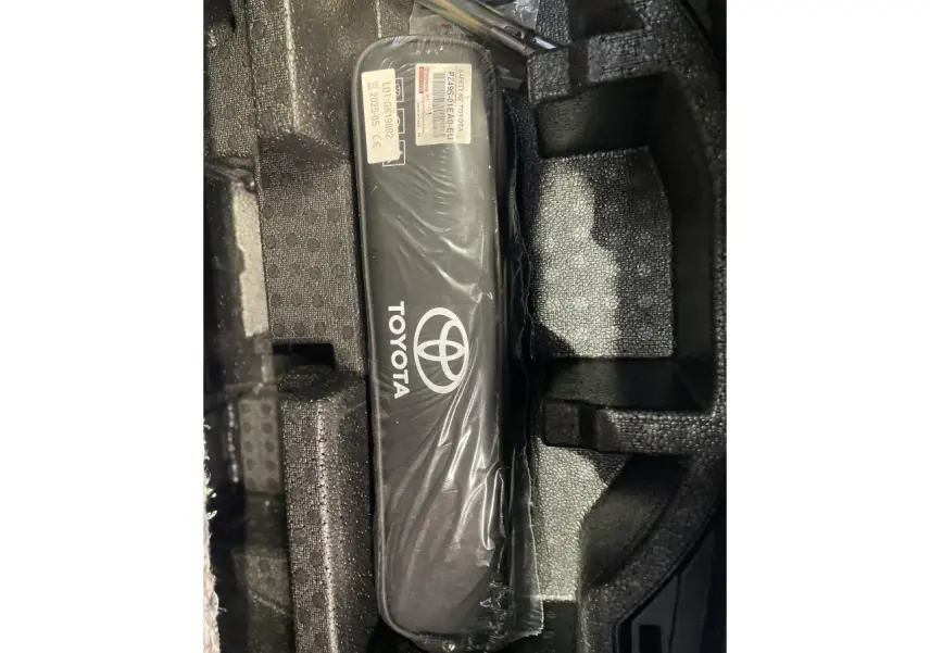 Gros plan sur un kit de sécurité Toyota noir dans un compartiment en mousse, accessoire d'origine Toyota visible.