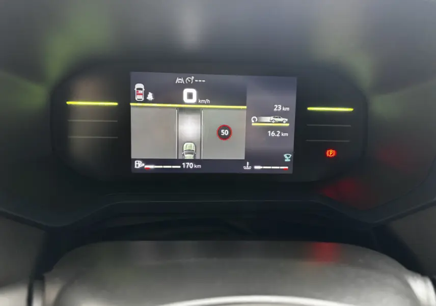 Combiné d'instruments numérique du Dacia Bigster 2025 affichant la vitesse, autonomie et alertes, vue frontale rapprochée.