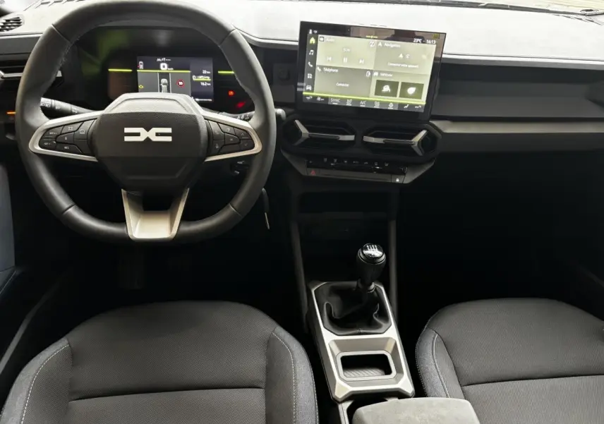 Vue intérieure du tableau de bord et volant cuir du Dacia Bigster 2025 avec écran tactile et boîte manuelle.