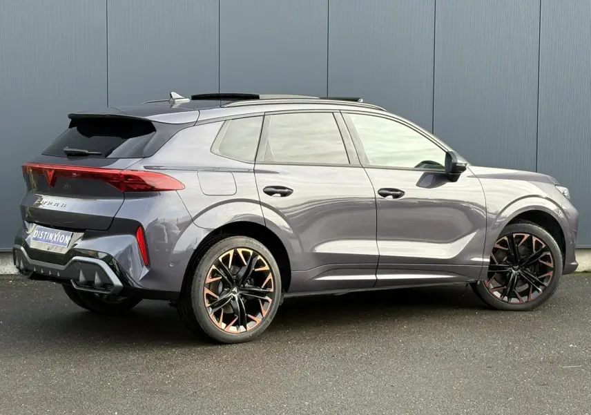 Vue 3/4 arrière droite de la CUPRA TERRAMAR 1.5 e-Hybrid gris Dark Void avec jantes cuivrées et toit ouvrant.