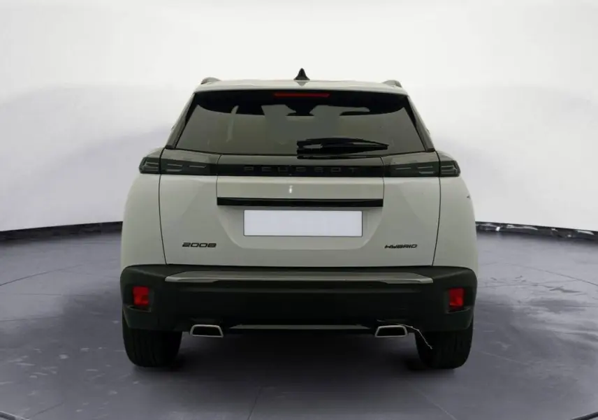 Vue arrière d’un Peugeot 2008 Hybrid blanc avec feux arrière noirs et double sortie d’échappement chromée.