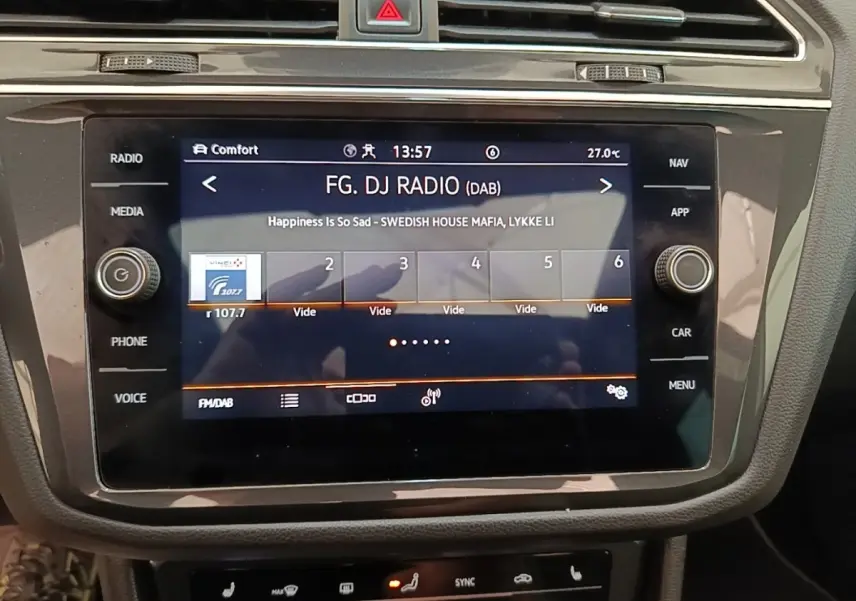 Écran tactile central du Volkswagen Tiguan 1.4 eHybrid 2023 affichant la radio FM/DAB en intérieur noir.