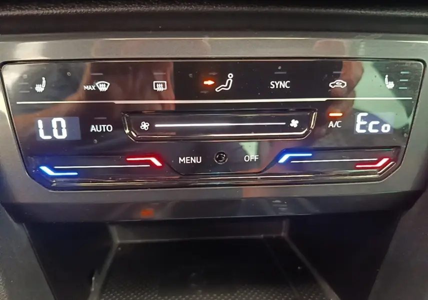 Panneau de commande de climatisation digitale du Volkswagen Tiguan blanc, affichage température et réglages en mode Eco.