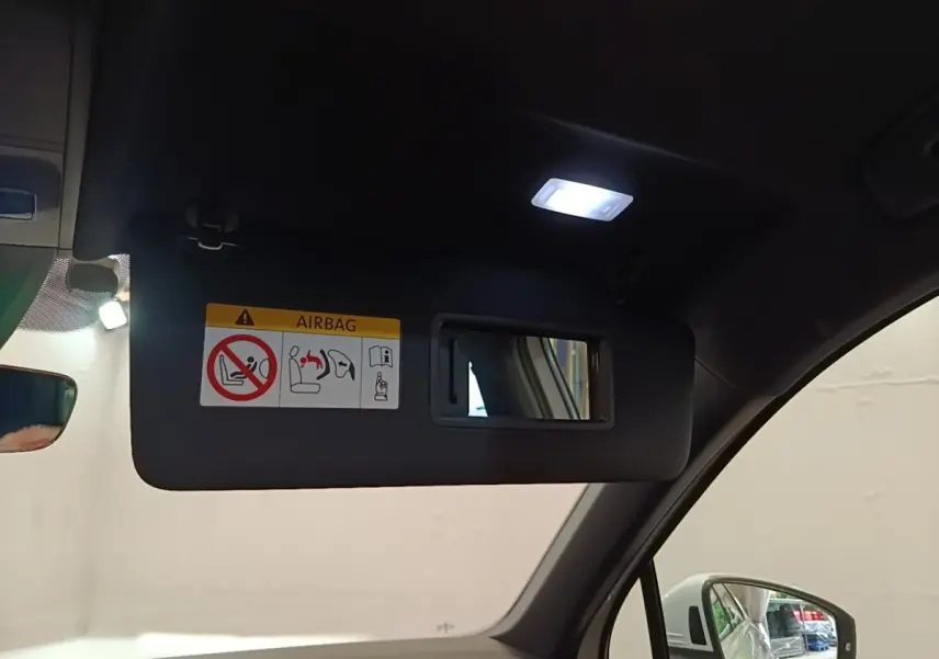 Détail du pare-soleil côté conducteur avec miroir et lumière allumée dans un Volkswagen Tiguan blanc 2023.