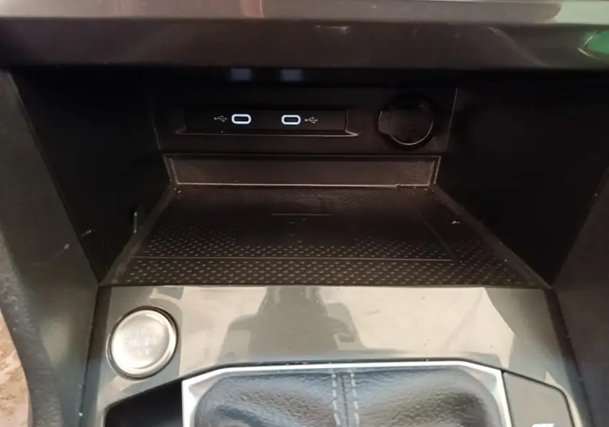 Gros plan sur la console centrale du Volkswagen Tiguan blanc 2023, avec bouton démarrage et ports USB visibles.