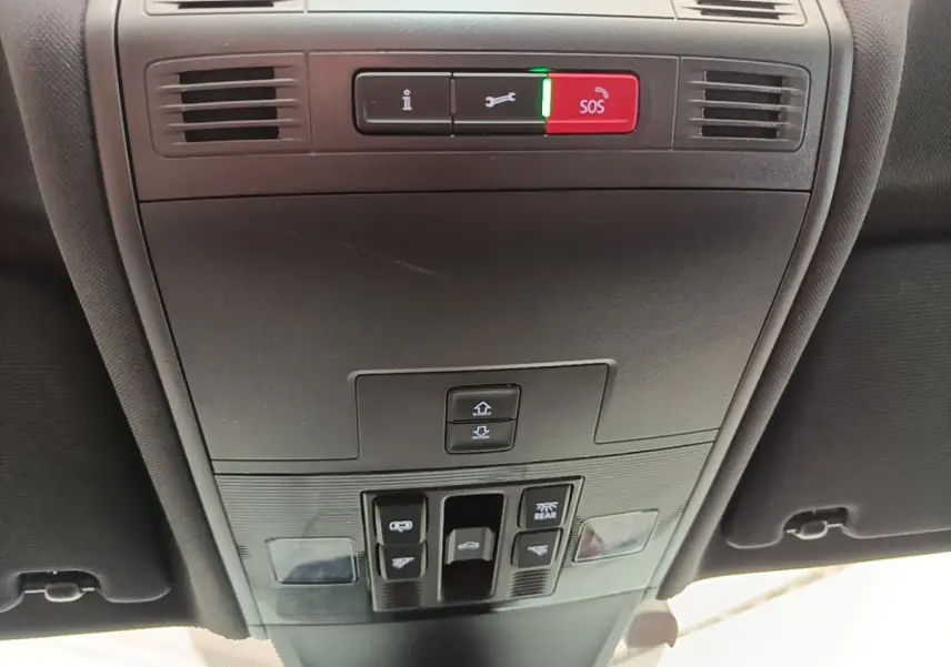 Vue intérieure du plafonnier avec commandes d’éclairage et bouton SOS du Volkswagen Tiguan blanc 2023 hybride rechargeable.