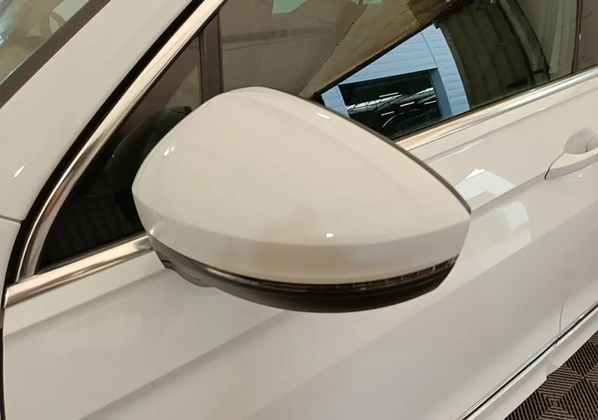 Rétroviseur électrique blanc côté conducteur du Volkswagen Tiguan 1.4 eHybrid 2023, vue rapprochée sur porte blanche.