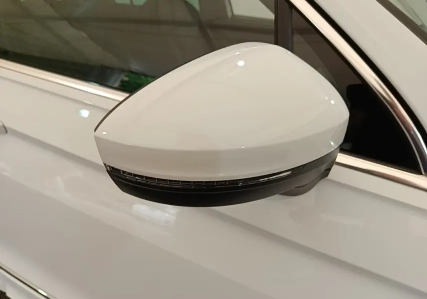 Rétroviseur électrique blanc côté gauche du Volkswagen Tiguan 1.4 eHybrid 2023 avec clignotant intégré.