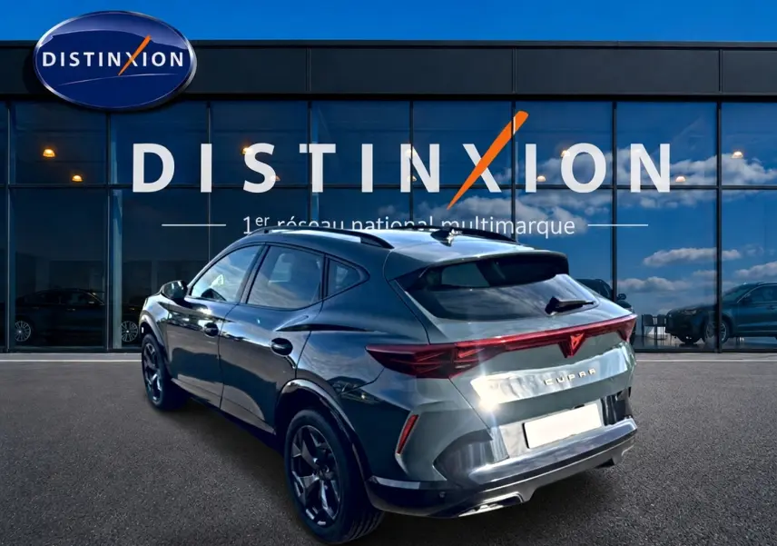Vue 3/4 arrière droite d’un CUPRA Formentor 1.5 etsi hybrid bleu fjord avec feux arrière LED et jantes 18 pouces noires.