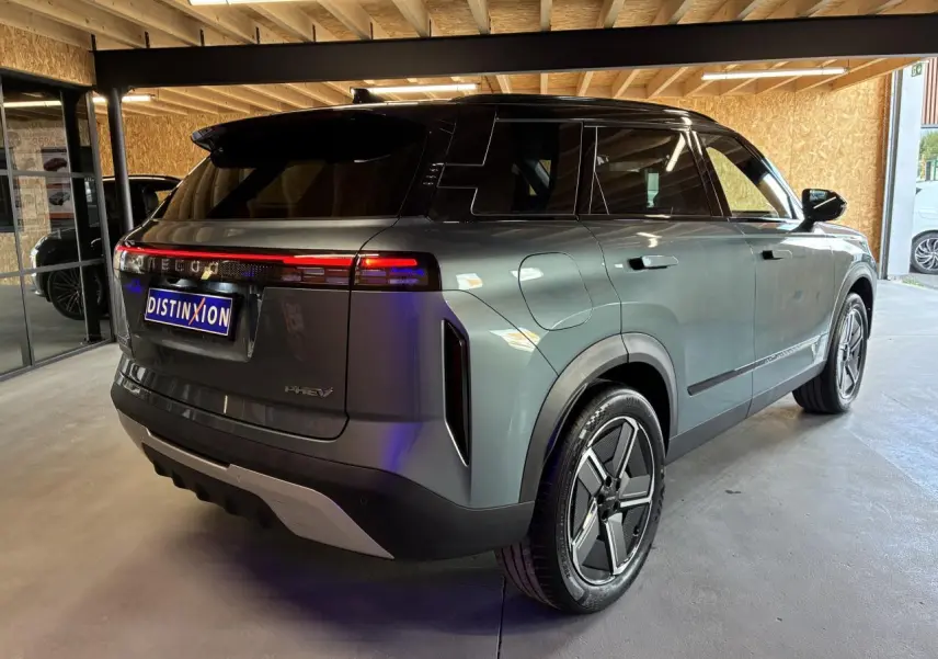 Vue 3/4 arrière droit du SUV JAECOO J7 gris olive avec toit noir et feux arrière LED continus.