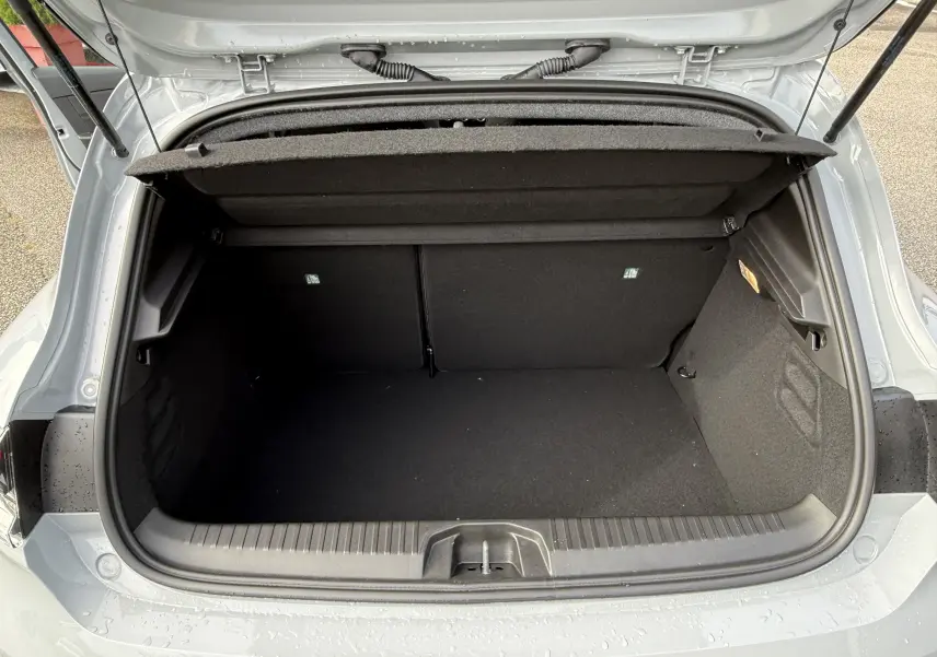 Coffre ouvert vu de l'arrière d'une Renault Clio V gris Rafale, montrant l'espace de chargement vide et la trappe de hayon.